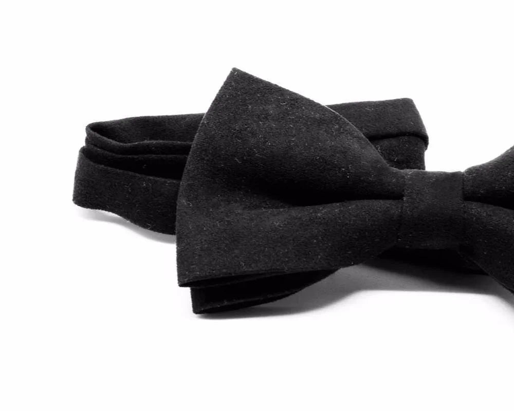 Pajarita negra de tela con diseño elegante y acabado artesanal sobre fondo blanco