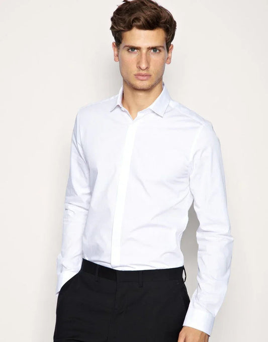 Hombre joven con camisa blanca entallada y pantalones negros, fondo neutro