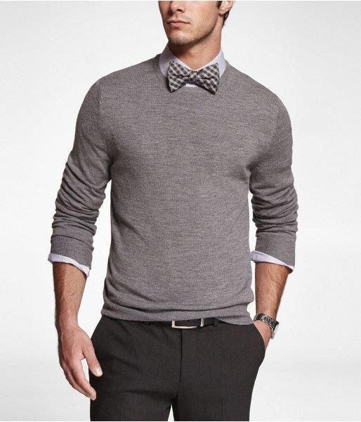Hombre vistiendo pajarita de cuadros gris con suéter gris y camisa blanca de manga larga, estilo formal casual
