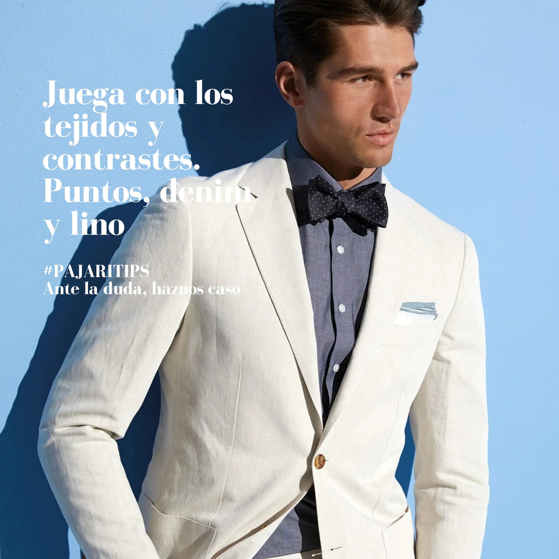 Hombre con americana de lino beige, camisa de denim azul y pajarita azul con lunares blancos en fondo azul